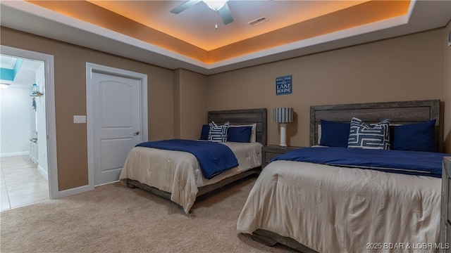 bedroom featuring carpet, ceiling fan, and a tray ceiling