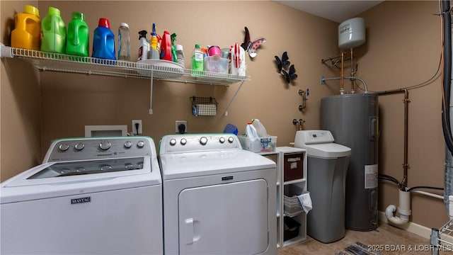 clothes washing area featuring washing machine and dryer and water heater