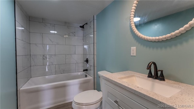 full bathroom featuring tiled shower / bath combo, vanity, and toilet