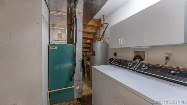 laundry room with heating unit, cabinets, washing machine and dryer, and water heater