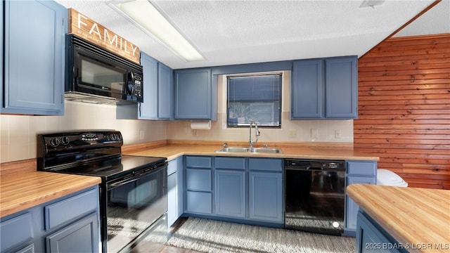 kitchen featuring sink, wooden counters, blue cabinetry, and black appliances