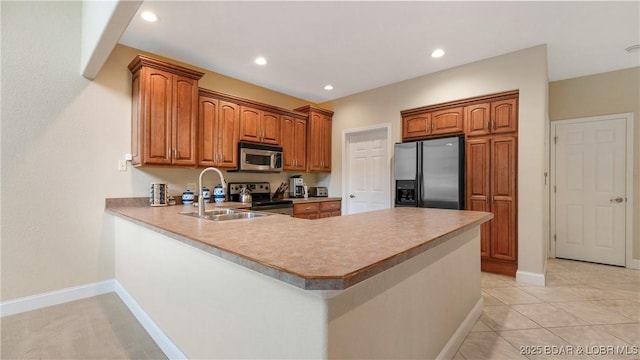 kitchen with sink, light tile patterned floors, stainless steel appliances, and kitchen peninsula