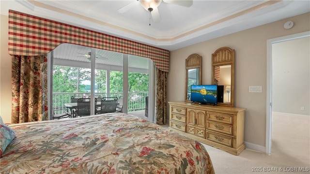 carpeted bedroom featuring access to exterior, a tray ceiling, ornamental molding, and ceiling fan