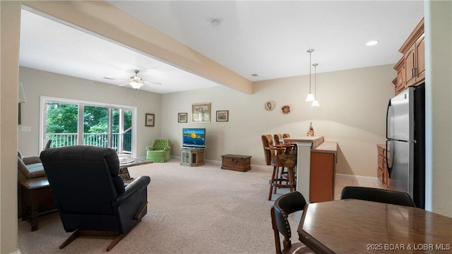 carpeted living room featuring beam ceiling and ceiling fan