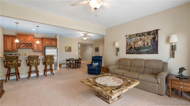 living room featuring light colored carpet, ceiling fan, and indoor bar