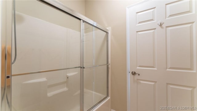 bathroom with bath / shower combo with glass door