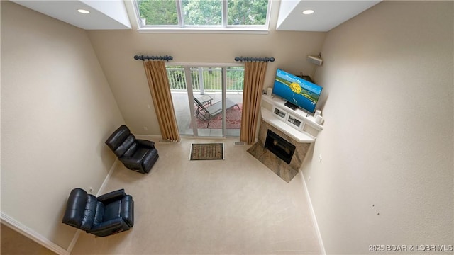 living room featuring a high end fireplace and carpet flooring