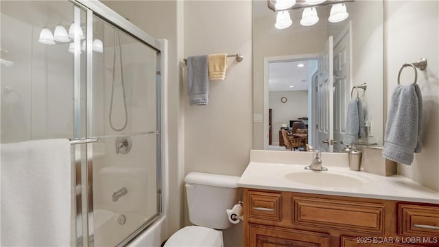 full bathroom with vanity, combined bath / shower with glass door, and toilet