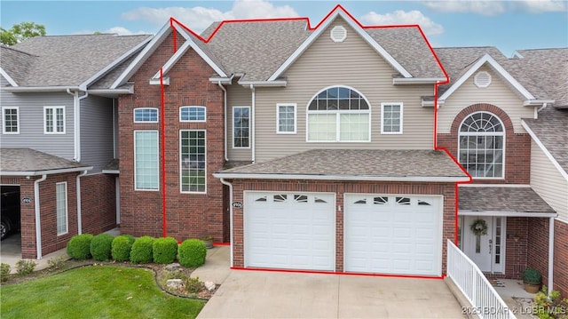 4906 Wilson Dr, Osage Beach, MO 65065 - traditional-style house with a garage, a shingled roof, driveway, and brick siding