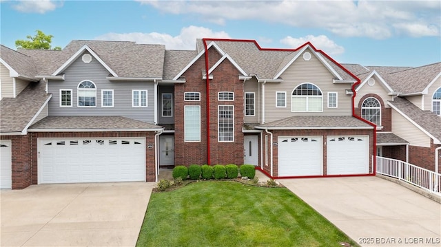 4906 Wilson Dr, Osage Beach, MO 65065 - traditional-style house featuring driveway, a front yard, a garage, brick siding, and a shingled roof