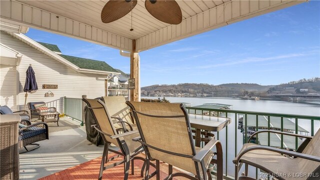 balcony featuring ceiling fan and a water view