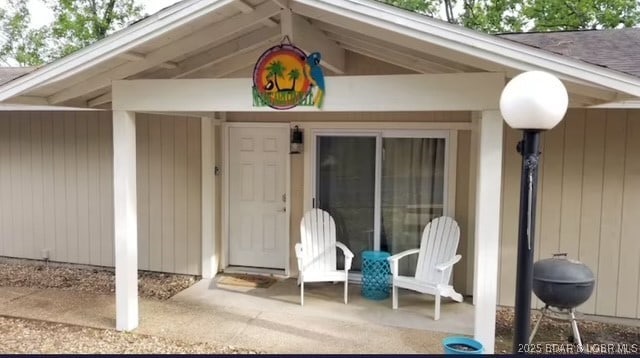 view of exterior entry with a patio