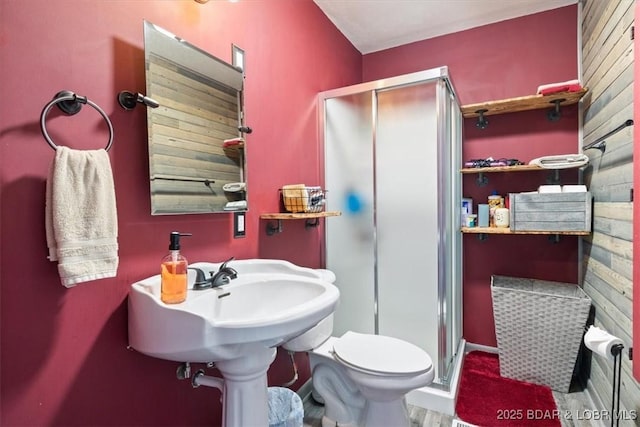 bathroom featuring toilet and a shower with shower door