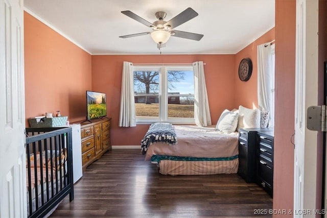 bedroom featuring crown molding, dark wood-type flooring, and ceiling fan