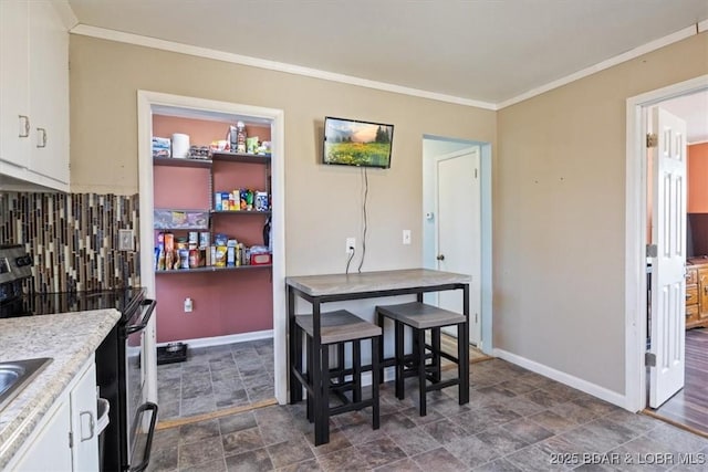 kitchen with white cabinetry, ornamental molding, stainless steel electric range oven, and decorative backsplash