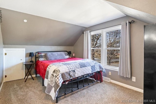 bedroom with carpet floors and vaulted ceiling