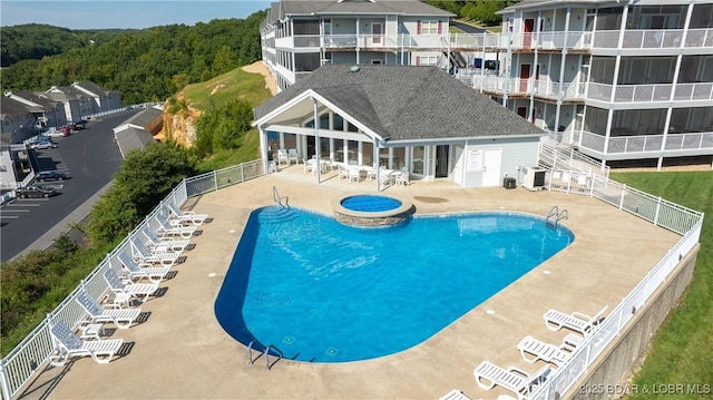 view of pool featuring a community hot tub, central AC, and a patio