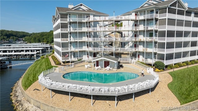 view of building exterior with a water view and a community pool