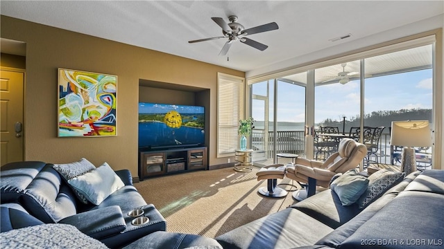 carpeted living room with ceiling fan