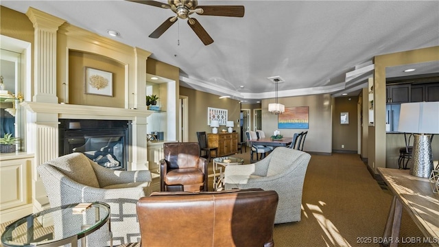 carpeted living room featuring a fireplace and ceiling fan