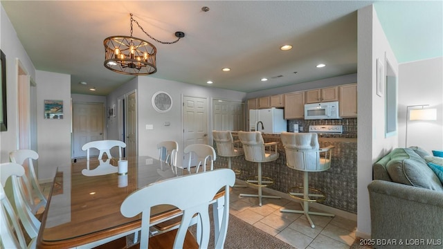 dining area featuring light tile patterned floors, a notable chandelier, and recessed lighting