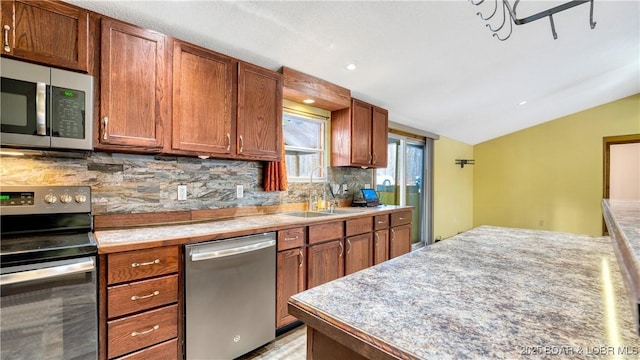 kitchen with vaulted ceiling, appliances with stainless steel finishes, sink, and decorative backsplash