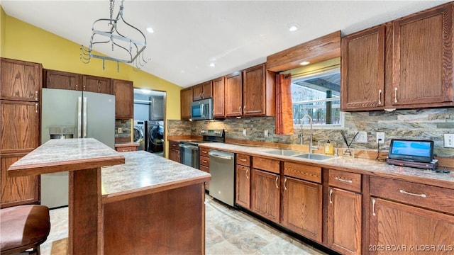 kitchen featuring lofted ceiling, sink, decorative light fixtures, a center island, and stainless steel appliances