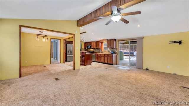 unfurnished living room with ceiling fan, light colored carpet, and vaulted ceiling