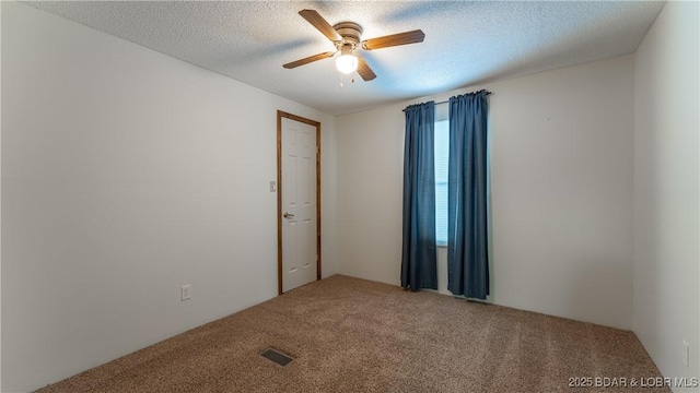 spare room with ceiling fan, carpet floors, and a textured ceiling