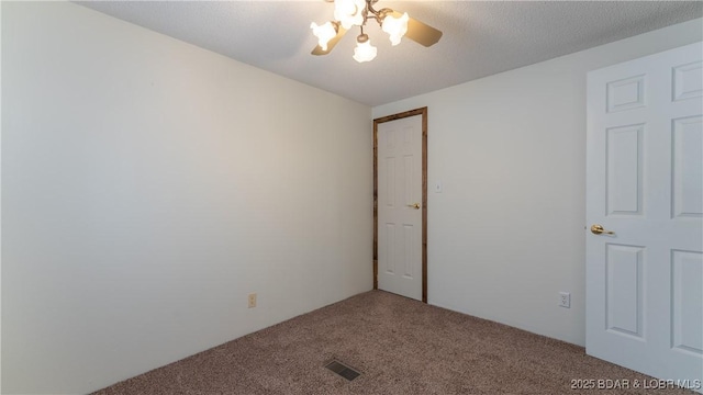 carpeted spare room featuring a textured ceiling