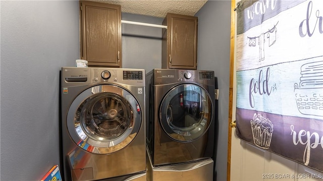 laundry area featuring separate washer and dryer, cabinets, and a textured ceiling