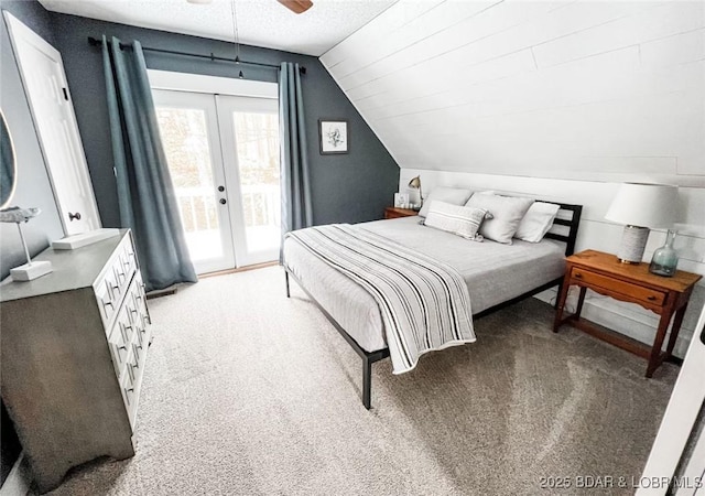 bedroom with lofted ceiling, carpet flooring, a textured ceiling, access to outside, and french doors