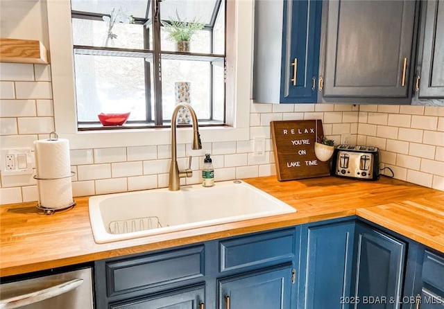 kitchen with a healthy amount of sunlight, sink, dishwasher, and blue cabinets