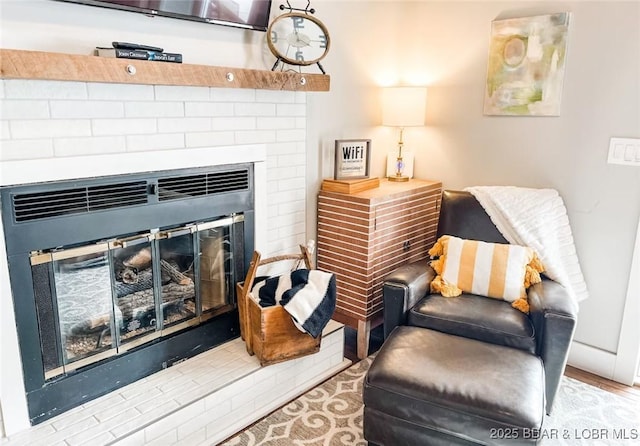 living area featuring a brick fireplace