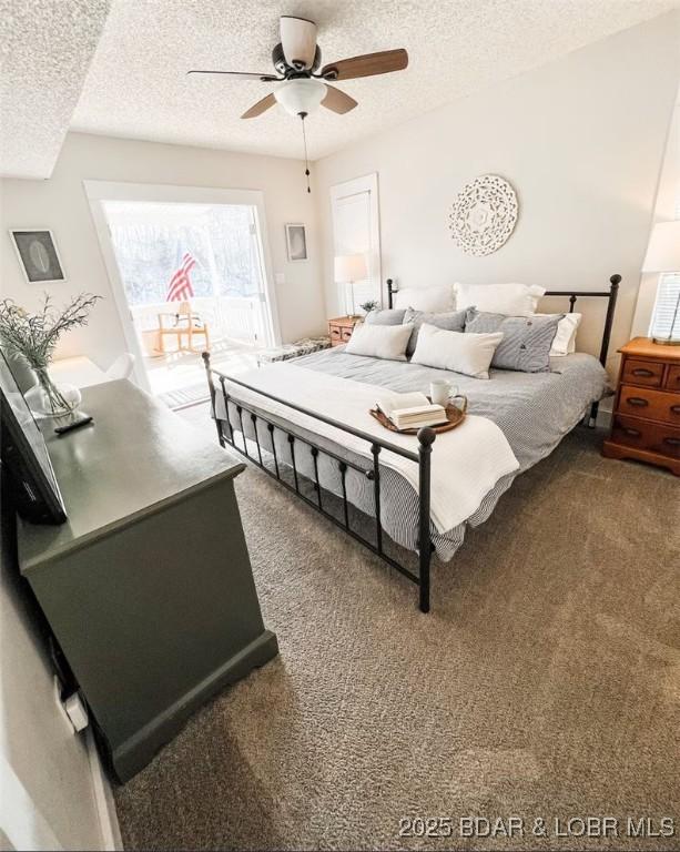 carpeted bedroom featuring ceiling fan and a textured ceiling