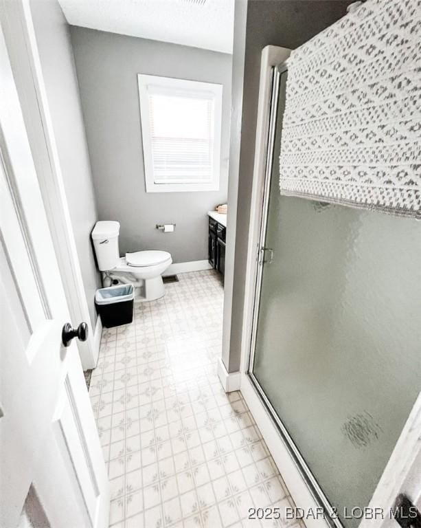 bathroom with vanity, a textured ceiling, toilet, and walk in shower