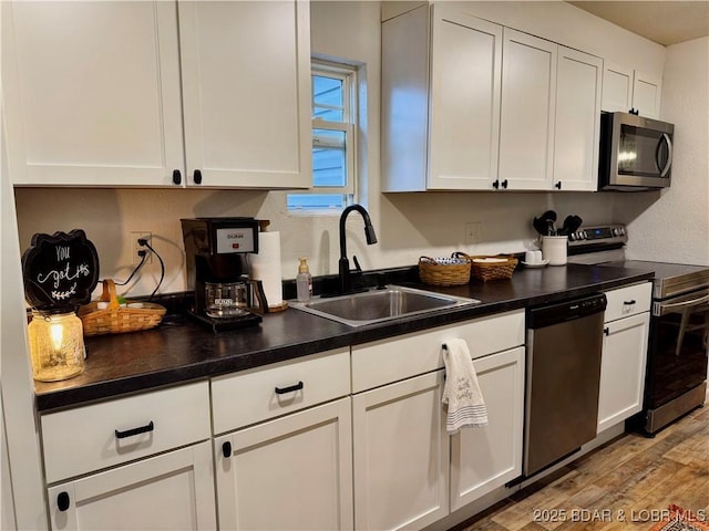 kitchen featuring white cabinetry, appliances with stainless steel finishes, sink, and light hardwood / wood-style flooring