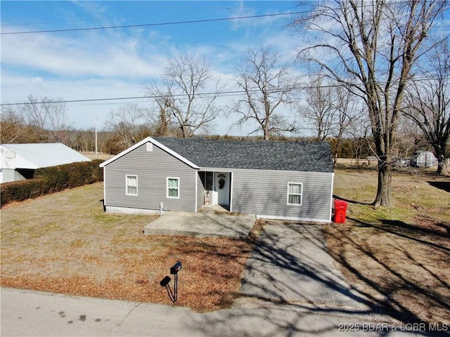 ranch-style home with a front lawn and a patio