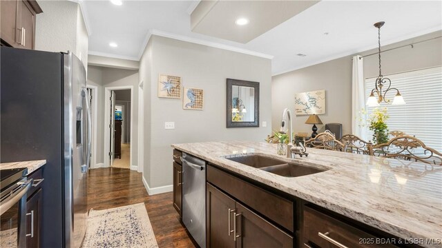 kitchen featuring dark wood-type flooring, sink, light stone counters, dark brown cabinets, and appliances with stainless steel finishes