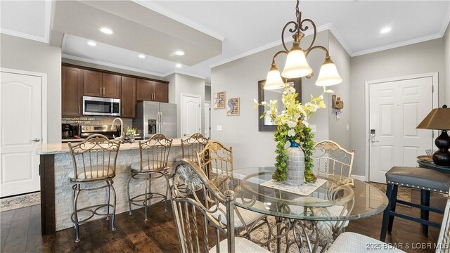 dining room with ornamental molding and dark hardwood / wood-style floors