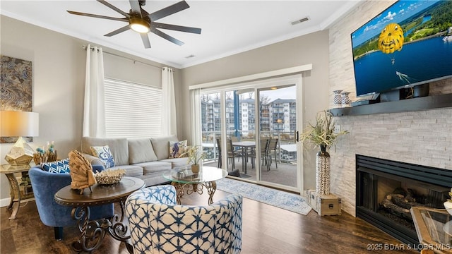 living area featuring crown molding, wood finished floors, a ceiling fan, and visible vents