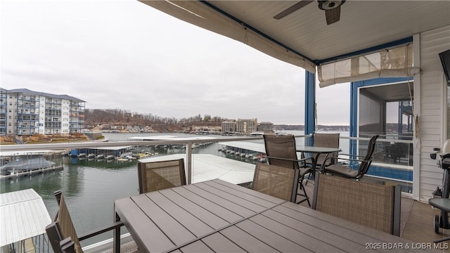 dock area with outdoor dining space, a view of city, and a water view