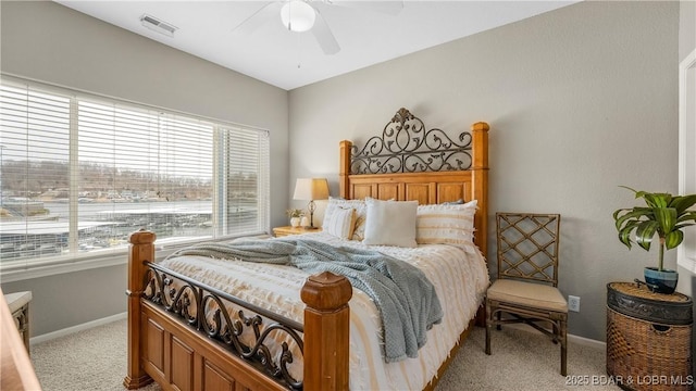 bedroom featuring visible vents, light colored carpet, baseboards, and ceiling fan