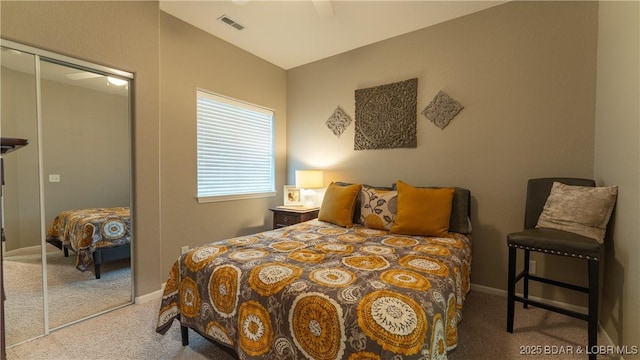 bedroom with a ceiling fan, baseboards, visible vents, carpet floors, and a closet