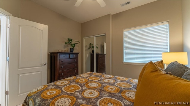 bedroom with a ceiling fan, visible vents, and a closet