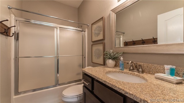 full bath featuring enclosed tub / shower combo, toilet, and vanity