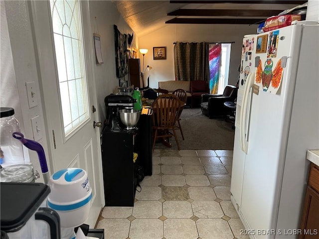 kitchen with lofted ceiling and white fridge with ice dispenser