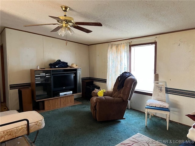 living room with ceiling fan, ornamental molding, a textured ceiling, and carpet