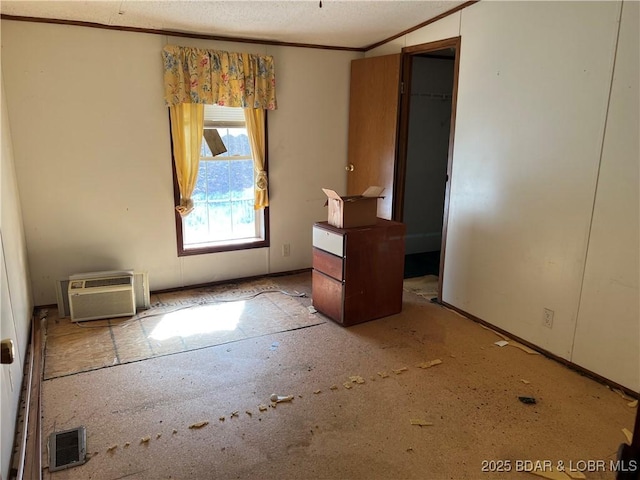 unfurnished bedroom featuring ornamental molding and a wall mounted air conditioner