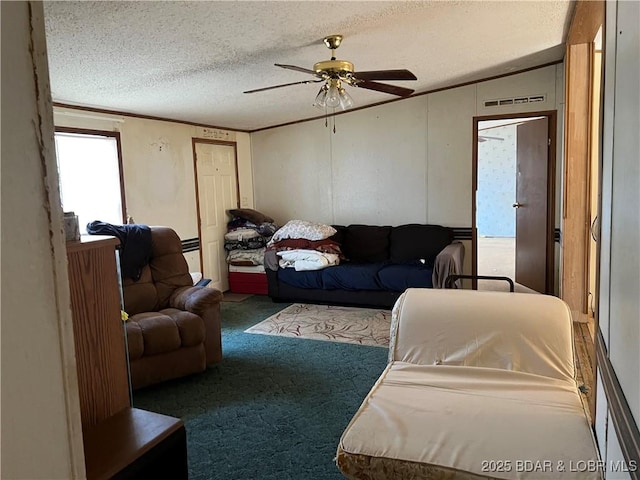 carpeted living room featuring crown molding, ceiling fan, and a textured ceiling